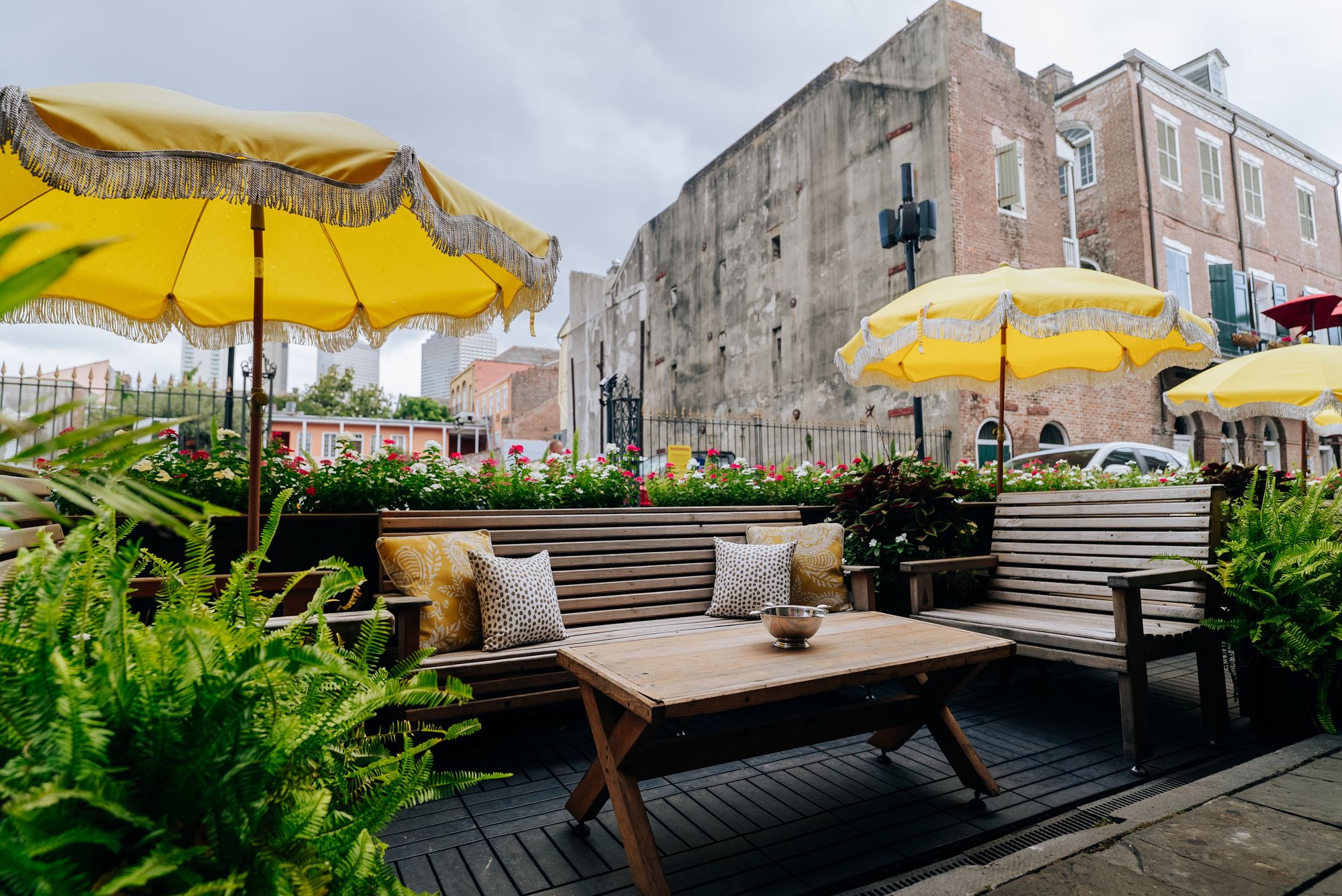 Outdoor lounge seating under yellow fringed umbrellas on Decatur Street