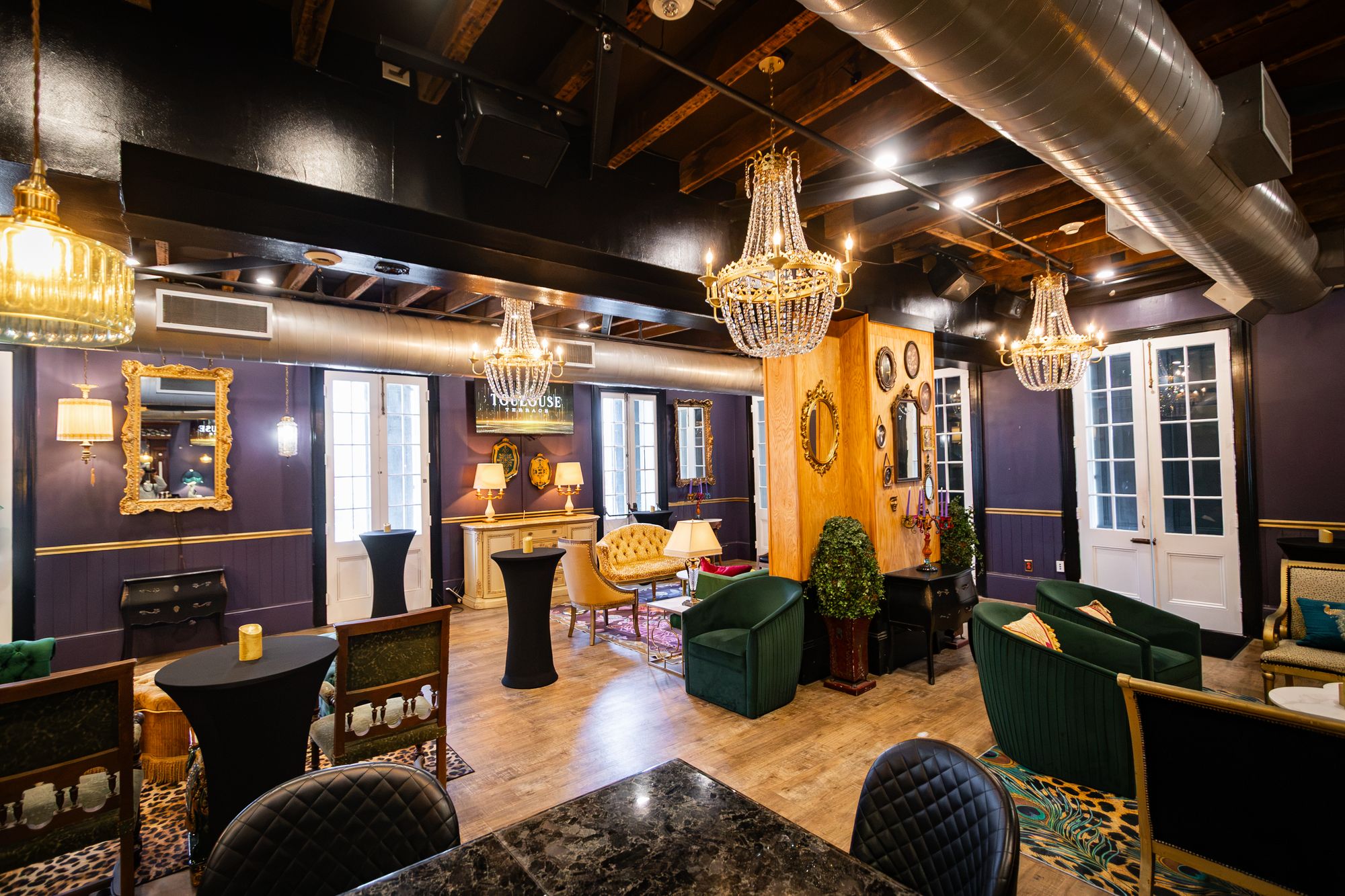 Event room seen from the bar, with chandeliers, French doors and lounge seating
