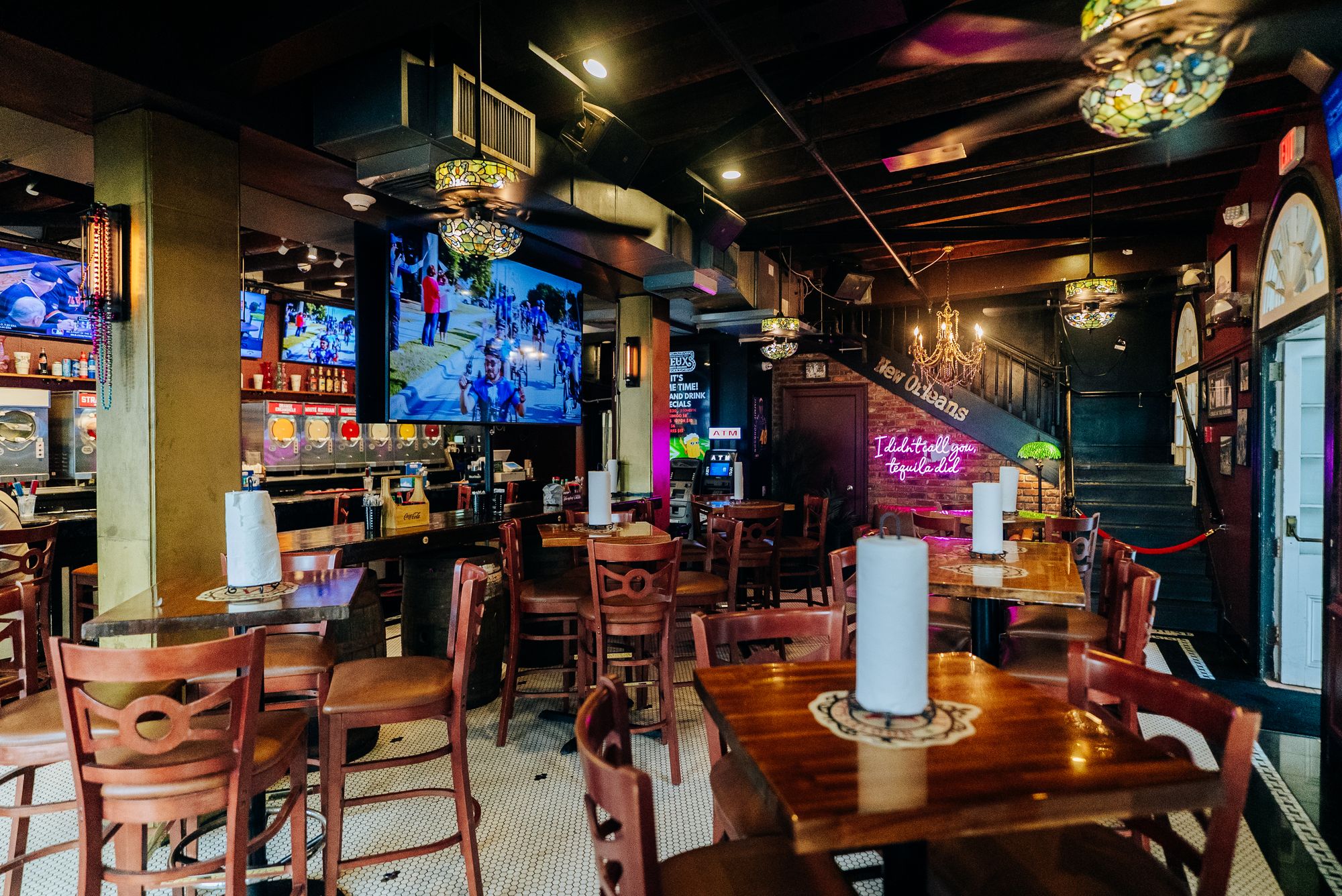 Saloon dining room with wood tables, chandeliers and big screens